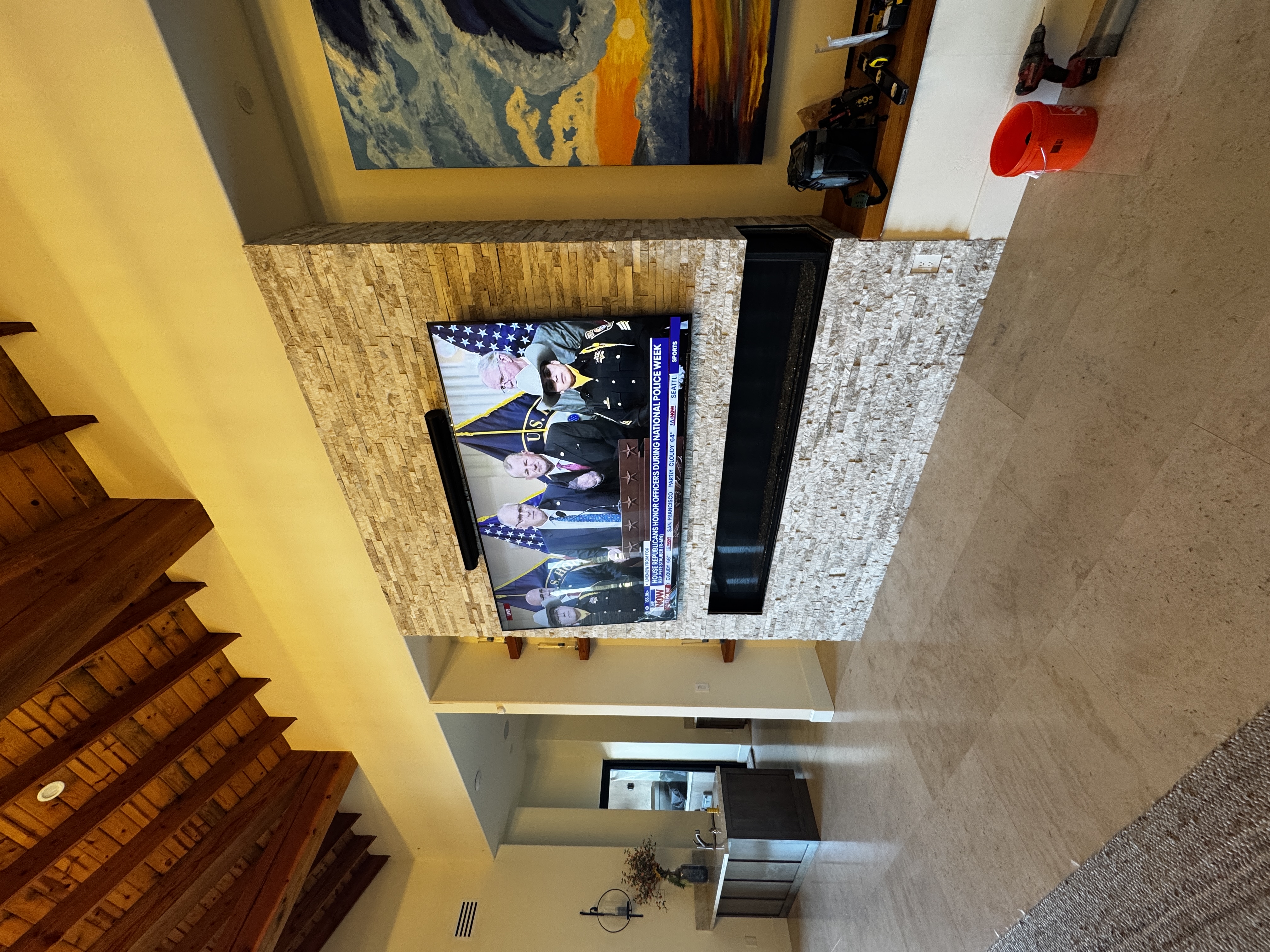 MKR Systems completed 100-inch TV installation on stacked stone wall above linear fireplace — San Diego luxury home with cedar beam ceiling